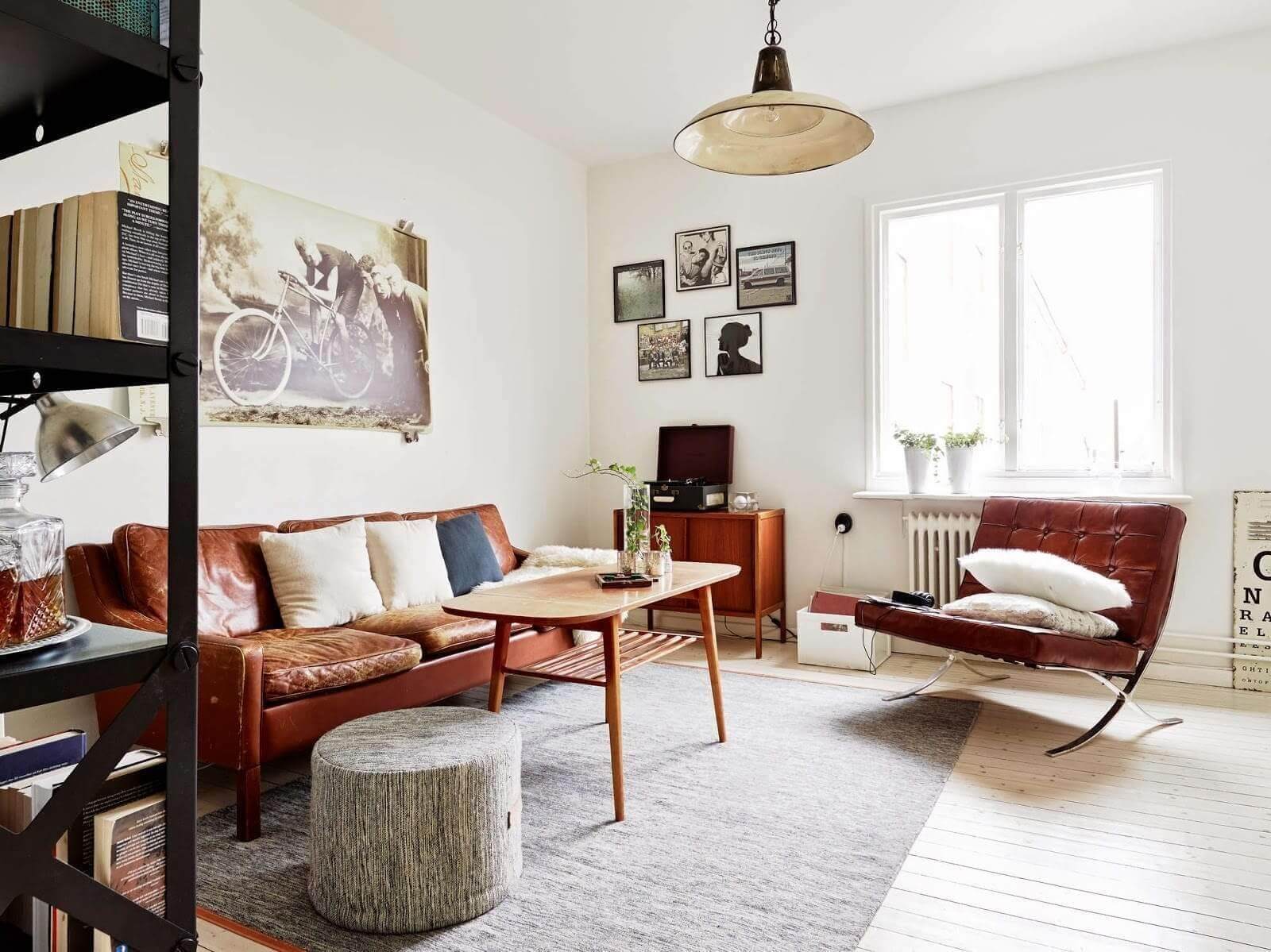Phòng khách phong cách vintage với ghế sofa da, tranh tường và ánh sáng tự nhiên.