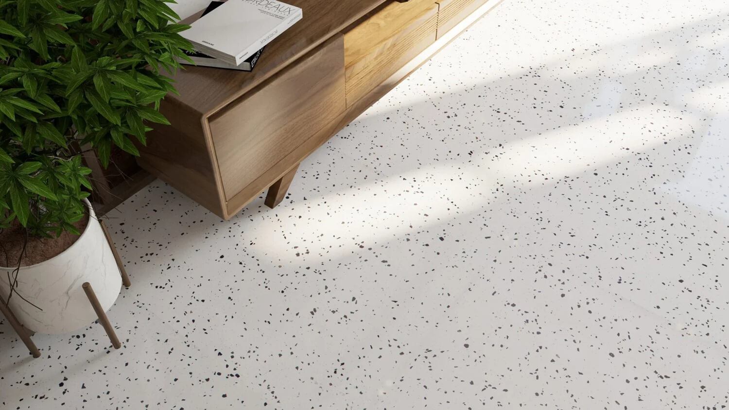 Nội thất phòng khách với sàn terrazzo trắng, kệ gỗ và cây cảnh xanh, ánh sáng tự nhiên chiếu qua cửa sổ.