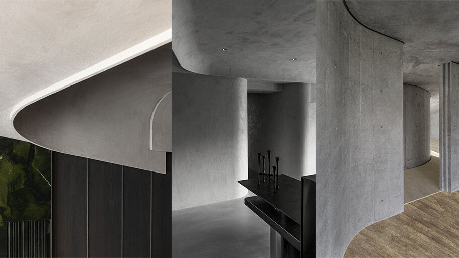 Không gian nội thất hiện đại với tường bê tông cong và sàn gỗ sáng màu, mang phong cách tối giản và sang trọng.