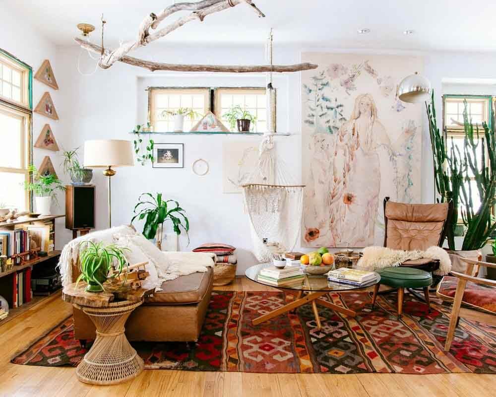 Phòng khách boho với cây xanh, thảm màu sắc, đèn đứng và tranh tường nghệ thuật, không gian ấm cúng và thư giãn.