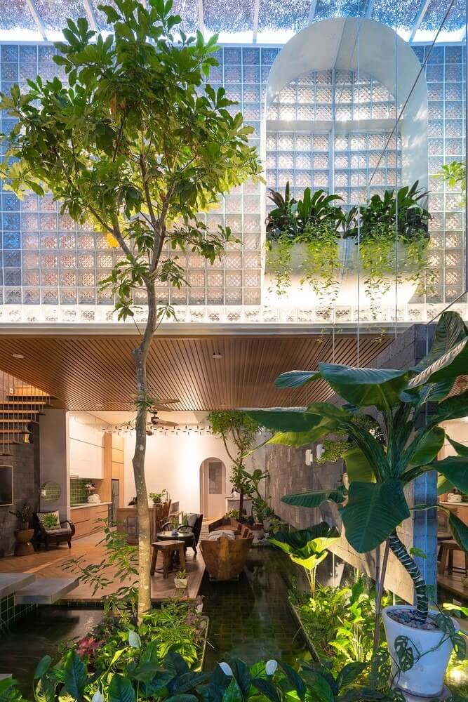 Nhà phố xanh với vườn cây và hồ nước trong nhà, thiết kế sáng tạo và thoáng đãng, tận dụng tối đa ánh sáng tự nhiên.