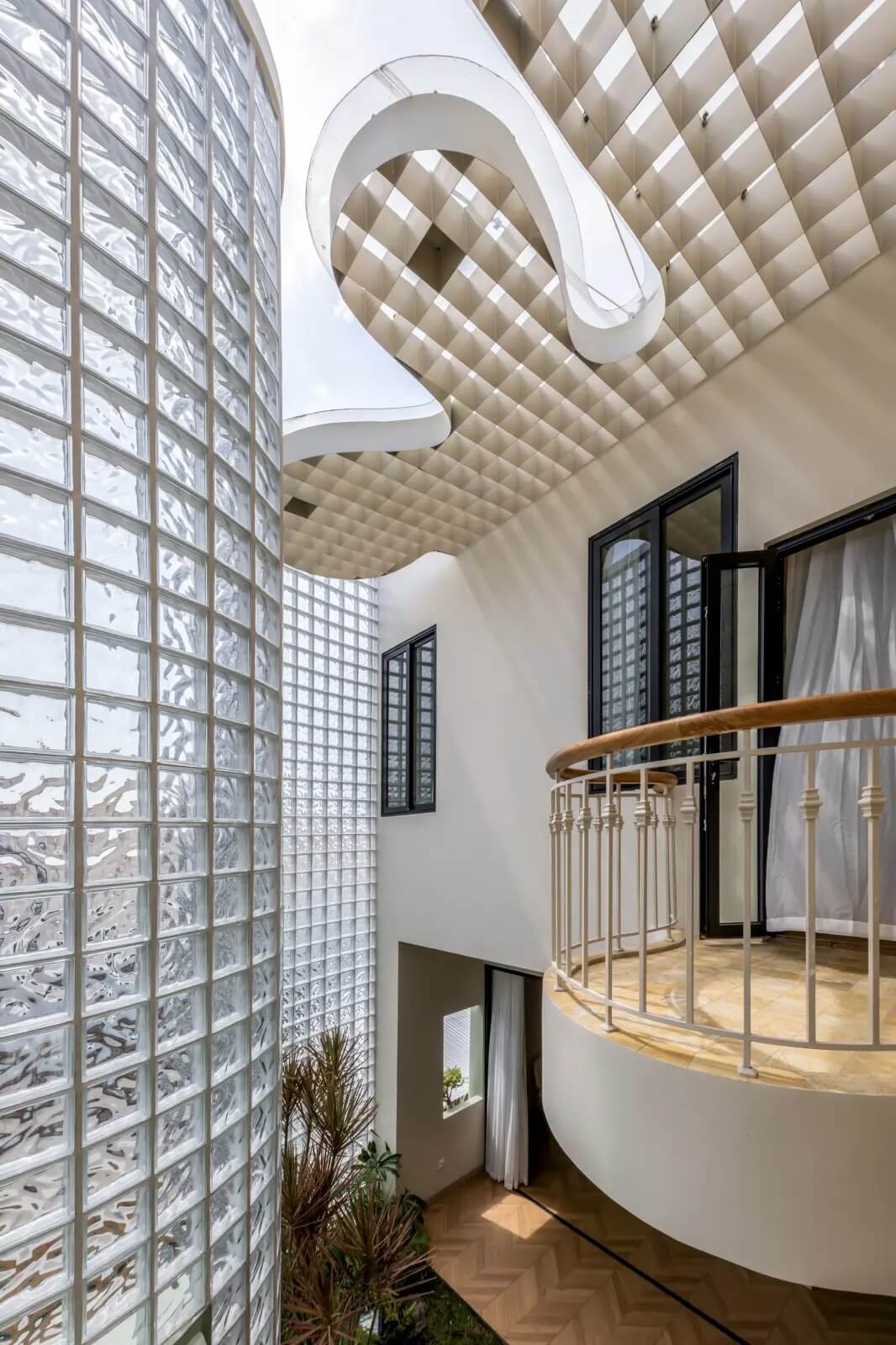 Thiết kế nội thất hiện đại với cửa kính và trần sáng tạo, tạo không gian mở và ánh sáng tự nhiên.