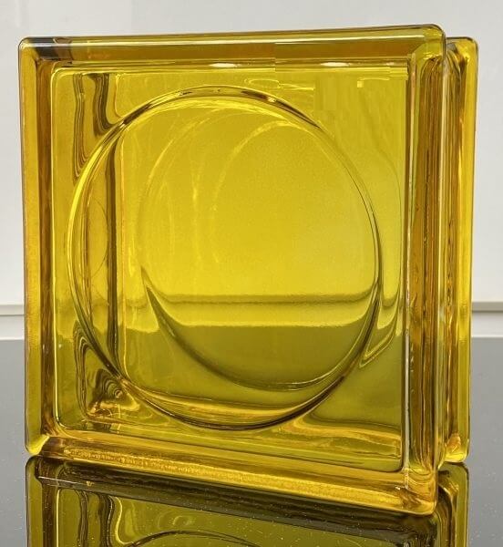 Gạch kính màu vàng trong suốt, hình vuông, bề mặt nhẵn, phản xạ ánh sáng đẹp.