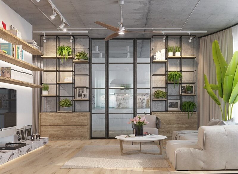 Phòng khách hiện đại với giá sách, cây xanh và bàn tròn, tạo không gian thoải mái và sang trọng.