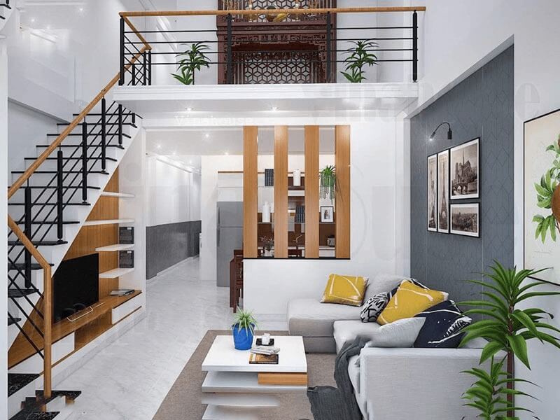 Phòng khách hiện đại với ghế sofa xám, bàn trắng, nội thất gỗ, cây xanh và cầu thang.