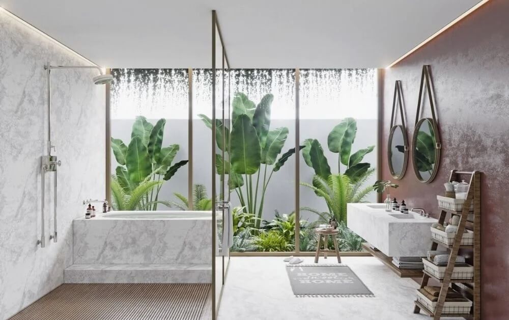 Phòng tắm hiện đại với bồn tắm đá trắng, cây xanh ngoài trời, gương đôi và ánh sáng tự nhiên.